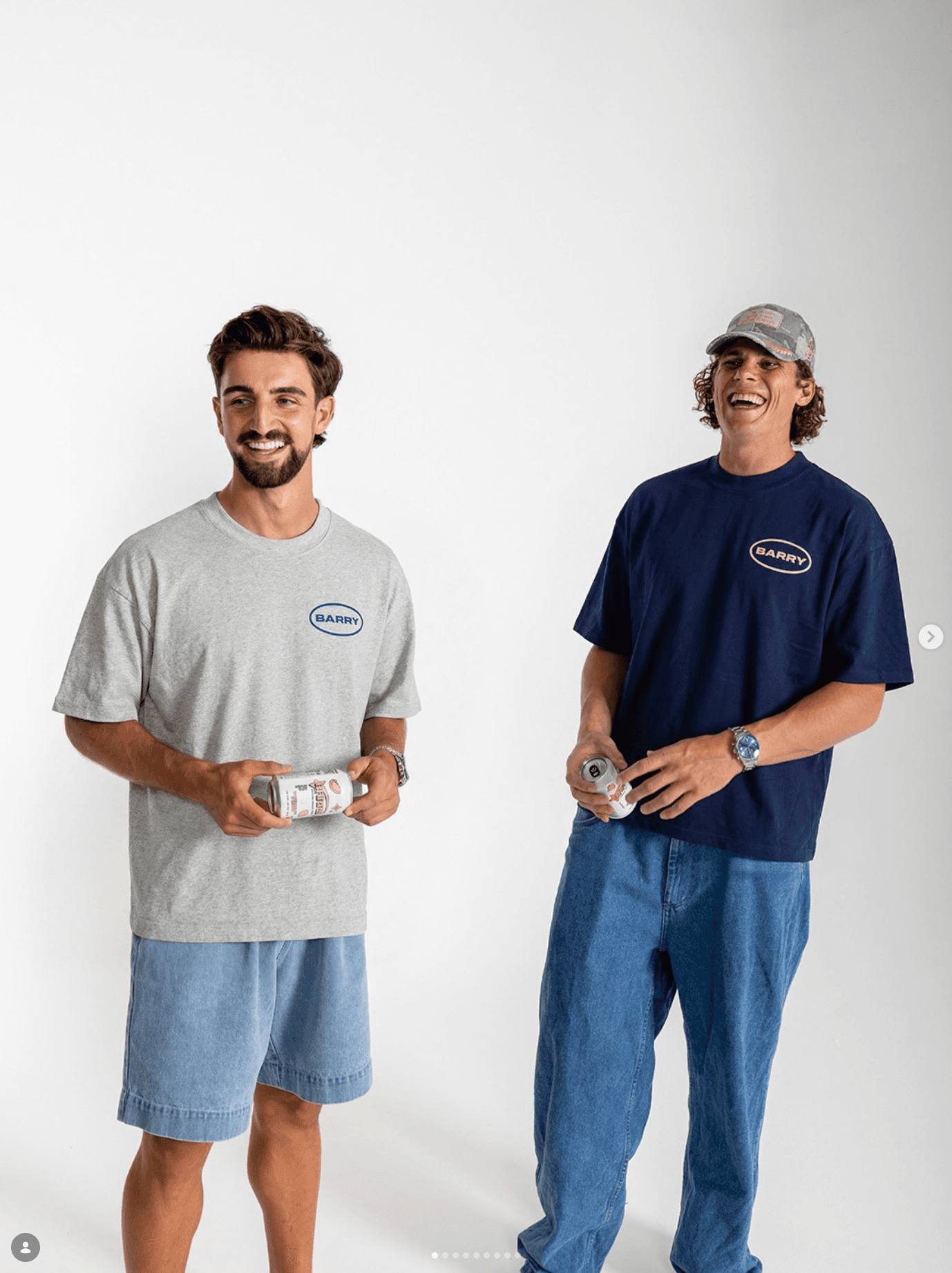 Two Barry founders in Barry shirts holding cans