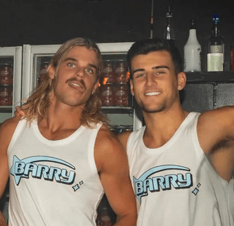 Two Barry founders wearing Barry tanks in front of a drinks fridge